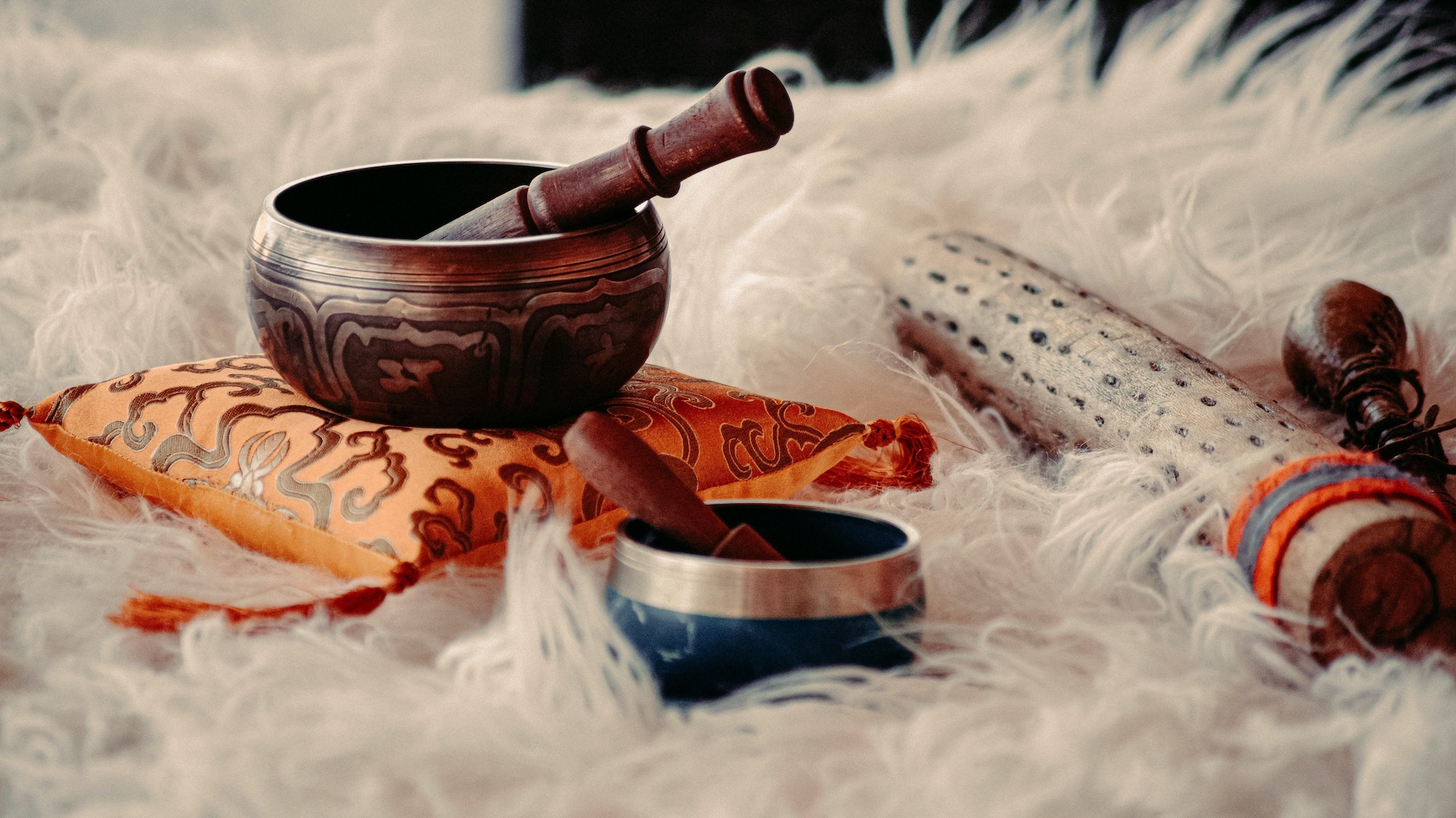 closeup of tibetan singing bowls and other shamanic tools for energy healing on a fluffy surface - Melanie Holden Psychic Energy Healer, Physical Therapist, and Reiki Master Teacher