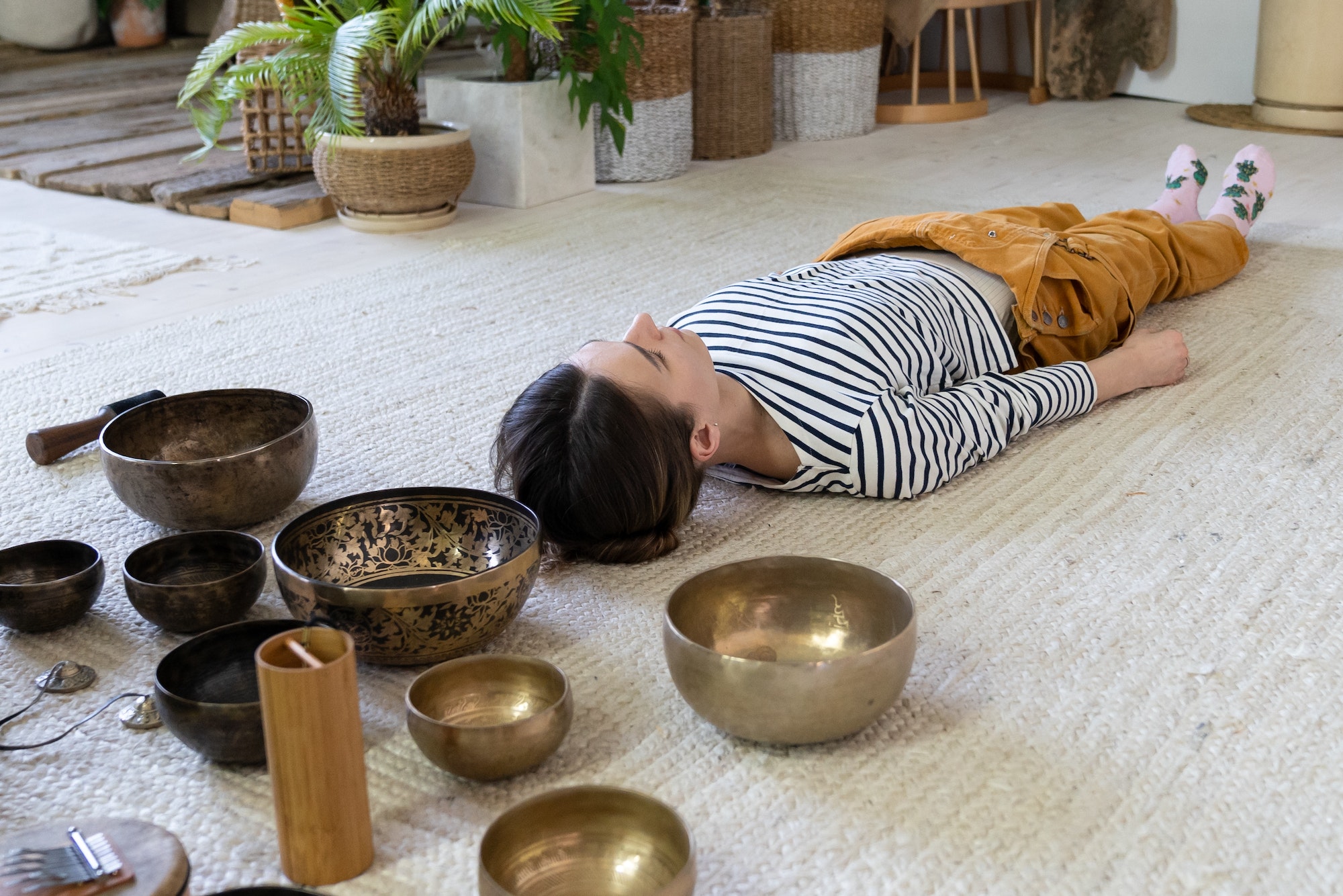 girl meditating with singing bowls during tibet massage and sound therapy tibetan spiritual practices. Services offered by Melanie Holden